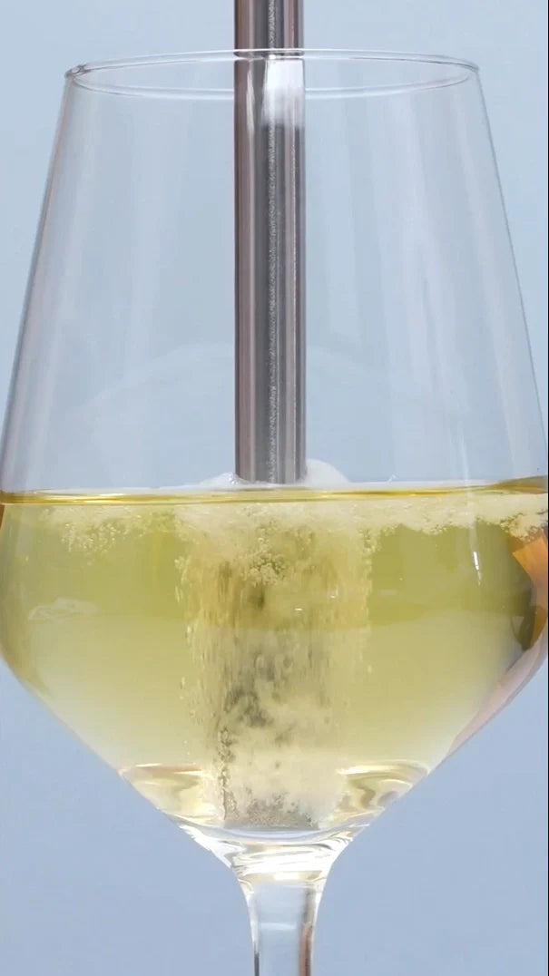 Loop of white wine being aerated with the Airtender Wine Aerator against a light blue background